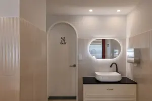 베이지 플루트 타일과 아치 도어의 세련된 파우더룸